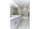 Well lit bathroom featuring dual sinks, a shower over bath and a modern grey color scheme at 16768 Sanctuary Dr, Winter Garden, FL 34787
