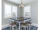 Dining area with a table and seating for four, with three windows providing natural light through plantation shutters at 16768 Sanctuary Dr, Winter Garden, FL 34787
