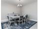 Dining room with a gray table, six chairs, a dresser, chandelier, and a blue rug at 16768 Sanctuary Dr, Winter Garden, FL 34787