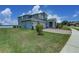 Side view of a two-story house with well-maintained landscaping and a three-car garage at 16768 Sanctuary Dr, Winter Garden, FL 34787