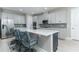 Spacious kitchen boasts white cabinets, stainless steel appliances, a mosaic backsplash, and a large island with seating at 16768 Sanctuary Dr, Winter Garden, FL 34787