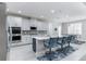 Modern kitchen featuring sleek white cabinets, stainless steel appliances, and a stylish island with bar seating at 16768 Sanctuary Dr, Winter Garden, FL 34787