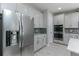 A bright kitchen features stainless steel appliances, white cabinets, mosaic backsplash, and light wood-look floors at 16768 Sanctuary Dr, Winter Garden, FL 34787