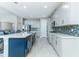 Open kitchen features an island, white cabinets, tiled backsplash, stainless steel appliances, and light wood-look floors at 16768 Sanctuary Dr, Winter Garden, FL 34787