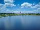 Scenic view of a tranquil lake, reflecting the clear blue sky, with homes visible in the distance at 16768 Sanctuary Dr, Winter Garden, FL 34787