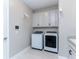 Laundry room with front loading washer and dryer plus upper cabinets at 16768 Sanctuary Dr, Winter Garden, FL 34787