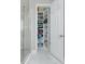 Bright white linen closet with fully stocked shelves, located adjacent to the shower at 16768 Sanctuary Dr, Winter Garden, FL 34787