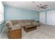 Spacious living room provides a cozy sectional, carpeted floors, and a ceiling fan at 16768 Sanctuary Dr, Winter Garden, FL 34787