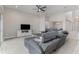 Spacious living room featuring a ceiling fan, a TV on an entertainment center, and a gray sofa at 16768 Sanctuary Dr, Winter Garden, FL 34787