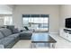Living room with a sectional sofa, coffee table, and sliding glass doors leading to the pool and lake view at 16768 Sanctuary Dr, Winter Garden, FL 34787