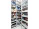 Walk-in pantry with white shelving and pull-out drawers, stocked with a variety of food and household items at 16768 Sanctuary Dr, Winter Garden, FL 34787