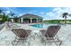 A pool with lounge chairs and shaded patio. Water and trees are visible in the background at 16768 Sanctuary Dr, Winter Garden, FL 34787