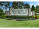 A sign reads 'Sanctuary at Twin Waters' with manicured hedges and blue flowers in front at 16768 Sanctuary Dr, Winter Garden, FL 34787