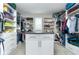 Organized walk-in closet with shelving, hanging rods, and an island with drawers at 16768 Sanctuary Dr, Winter Garden, FL 34787