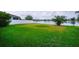 Waterfront backyard with lush green grass and a white fence, offering serene views and privacy at 1748 Thetford Cir, Orlando, FL 32824