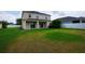 Large backyard with green grass, covered patio, and a partial view of the house at 1748 Thetford Cir, Orlando, FL 32824