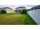 Expansive backyard featuring lush green grass and a white privacy fence, perfect for outdoor activities at 1748 Thetford Cir, Orlando, FL 32824