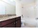 Bathroom featuring granite countertops, a modern vanity, and a shower-tub combination with tiled walls at 1748 Thetford Cir, Orlando, FL 32824
