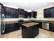 Modern kitchen with dark cabinetry, granite countertops, and stainless steel appliances at 1748 Thetford Cir, Orlando, FL 32824