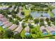 Stunning aerial view of a neighborhood, showing the homes, lake, green spaces, and landscaping at 17614 Woodcrest Way, Clermont, FL 34714