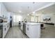 Bright, white kitchen featuring an island and views of the living room at 17614 Woodcrest Way, Clermont, FL 34714