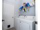 Bright laundry room featuring a washer, dryer and wall-mounted shelving for storage at 17614 Woodcrest Way, Clermont, FL 34714