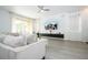 Bright living room has gray plank floors, a ceiling fan, and a sliding door to a patio or porch at 17614 Woodcrest Way, Clermont, FL 34714