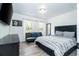 Main bedroom with modern decor, a comfortable bed, TV, and natural light at 17614 Woodcrest Way, Clermont, FL 34714
