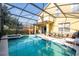 Lush screened-in pool with hot tub, outdoor seating, and a summer kitchen at 17614 Woodcrest Way, Clermont, FL 34714