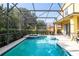 Beautiful screened-in pool with hot tub, patio space, and lush landscaping at 17614 Woodcrest Way, Clermont, FL 34714