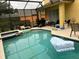 Screened-in pool area with spa, chairs, and a grill, perfect for outdoor entertaining and relaxation at 17614 Woodcrest Way, Clermont, FL 34714