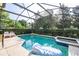 Sparkling screened-in pool with lounge chairs, mature landscaping, and a hot tub for relaxation at 17614 Woodcrest Way, Clermont, FL 34714