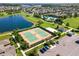 Aerial view featuring community tennis courts, a beach volleyball court, and a large parking area at 18309 Oliver Twist Way, Winter Garden, FL 34787