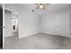 Clean, carpeted bedroom with ceiling fan and view to hallway at 18309 Oliver Twist Way, Winter Garden, FL 34787