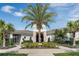 Exterior view of The Summit clubhouse entrance with palm trees, lush landscaping, and covered entryway at 18309 Oliver Twist Way, Winter Garden, FL 34787