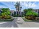A grand community entrance framed by tropical landscaping and a welcoming pathway at 18309 Oliver Twist Way, Winter Garden, FL 34787
