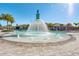 Large community pool featuring a splash fountain, poolside seating, palm trees, and clear skies at 18309 Oliver Twist Way, Winter Garden, FL 34787