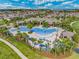 Aerial view of large community pool and clubhouse with lounge seating, surrounded by palm trees and greenery at 18309 Oliver Twist Way, Winter Garden, FL 34787