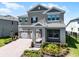 Beautiful home featuring a three-car garage, covered porch, well-kept landscaping, and brick paver driveway at 18309 Oliver Twist Way, Winter Garden, FL 34787