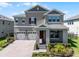 Charming two-story home with a three-car garage, brick paver driveway, and manicured landscaping at 18309 Oliver Twist Way, Winter Garden, FL 34787