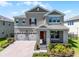 Stunning two-story home with a three-car garage, brick paver driveway, and manicured landscaping at 18309 Oliver Twist Way, Winter Garden, FL 34787