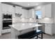 Modern kitchen with stainless steel appliances, white cabinets, and an island with bench seating at 18309 Oliver Twist Way, Winter Garden, FL 34787