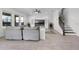 Bright living room featuring hardwood floors, ceiling fan, adjacent to a staircase with metal spindles at 18309 Oliver Twist Way, Winter Garden, FL 34787