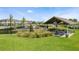 Community playground featuring green grass, covered picnic tables and neighborhood homes in the background at 18309 Oliver Twist Way, Winter Garden, FL 34787