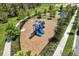 Aerial view of a modern community playground with slides and climbing structure surrounded by a black fence at 18309 Oliver Twist Way, Winter Garden, FL 34787