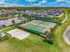 Aerial view of tennis and beach volleyball courts surrounded by landscaped grounds and community homes at 18309 Oliver Twist Way, Winter Garden, FL 34787