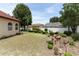 Lush backyard with well-kept lawn, garden area and a large shade tree offering ample privacy at 2021 Wildfire Ct, Apopka, FL 32703