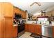 Well-lit kitchen with stainless steel appliances and wooden cabinets at 2021 Wildfire Ct, Apopka, FL 32703