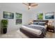 Staged bedroom with natural light, ceiling fan and wall-mounted television at 215 Bradbury Ave, Oak Hill, FL 32759