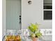 Charming front door with a 'Hello Sunshine' welcome mat and potted plant at 215 Bradbury Ave, Oak Hill, FL 32759